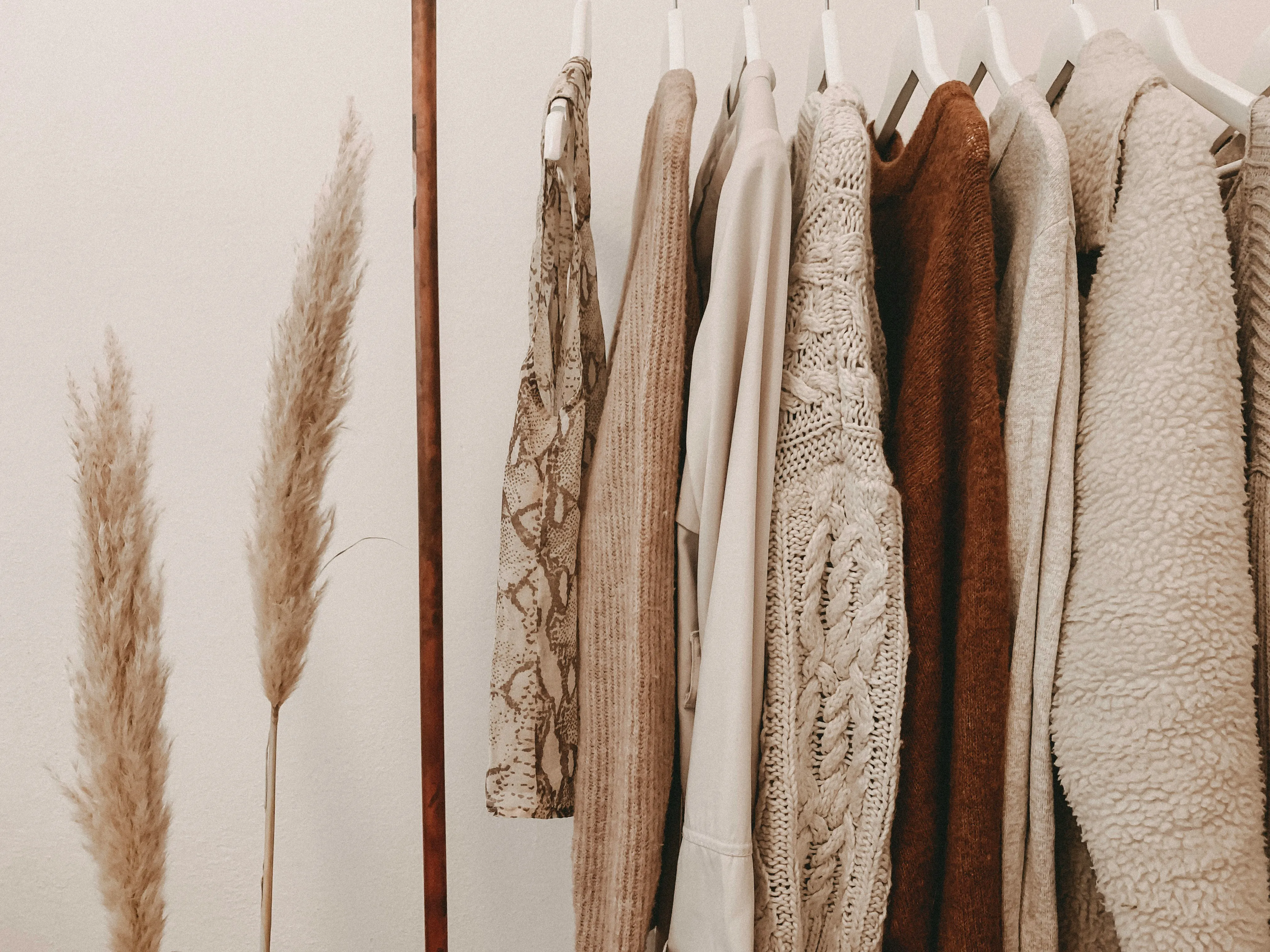 A beautifully curated closet with warm-toned clothing
